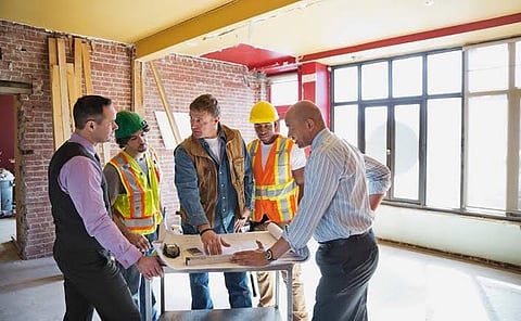 Construction team discussing building plans at a renovation site