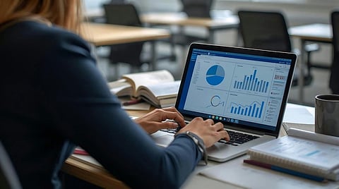 Person working on a laptop displaying business analytics charts and graphs