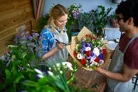 Florists arranging a colorful bouquet of flowers in a shop