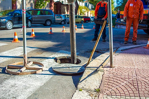 Workers repairing a manhole on a city street.