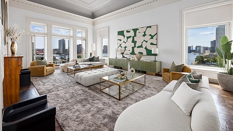 Sunlit Manhattan luxury co-op living room with high ceilings and East River skyline views