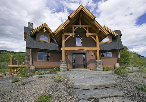 Large rustic house with timber beams and stone details.