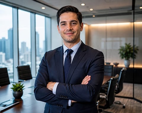 Businessman in a suit standing confidently in a modern office.