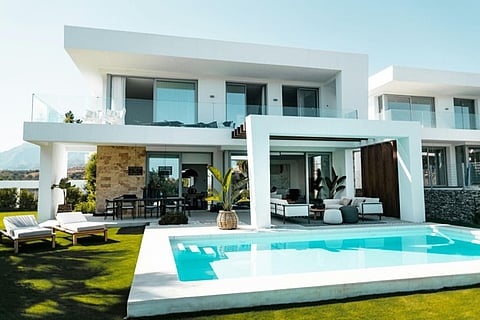 Modern luxury villa with a private swimming pool and outdoor lounge area.