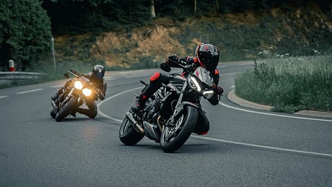 Two motorcyclists navigate a winding road