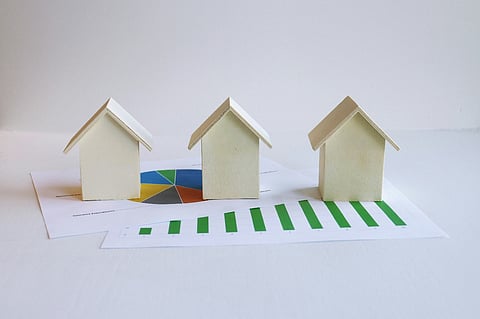 Three wooden houses placed on a paper