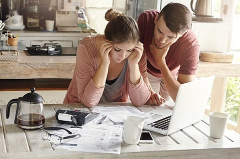 Stressed couple reviewing bills.