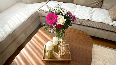 Flowers and candles on a coffee table.