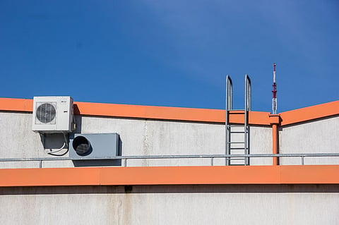 Building exterior with AC unit and ladder.