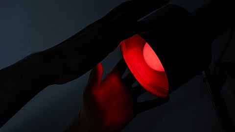 Hands adjusting a red light lamp