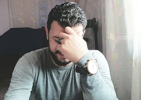 Stressed man covering his face.