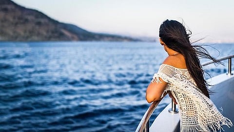 Woman on a boat looking at the sea.