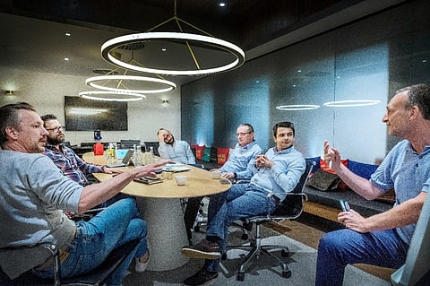 Six men having a meeting in a conference room.