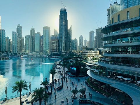Modern city skyline and waterfront promenade.