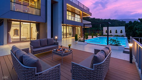 Modern luxury villa with pool at dusk.