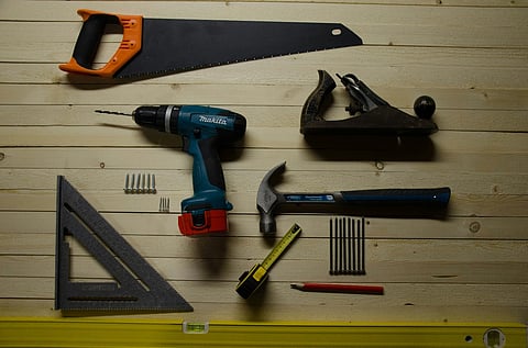 Assorted carpentry tools on a wooden surface.