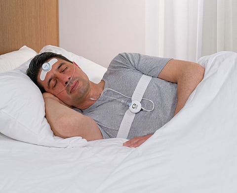 Man sleeping with a sleep monitor.