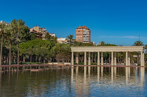 Colonnade by a reflecting pool in a park.