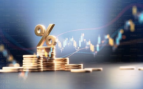 Percentage sign on stacked coins with stock charts.