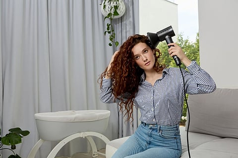 Woman drying curly hair.