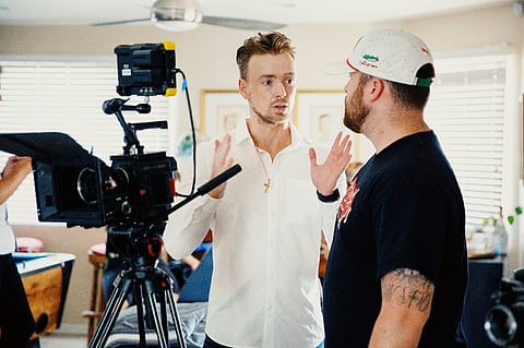Two men talking near a video camera
