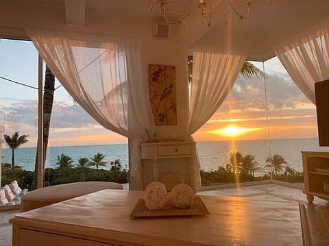 Ocean sunset viewed through large windows.
