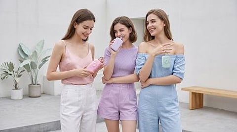 Three women holding portable power banks.