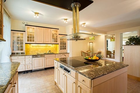 Kitchen island with a cooktop and hood.