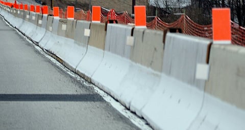 Concrete construction barriers along a roadway.