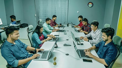 Team working on laptops at an office desk.