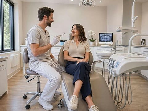 Dentist talking with a patient in an exam room.