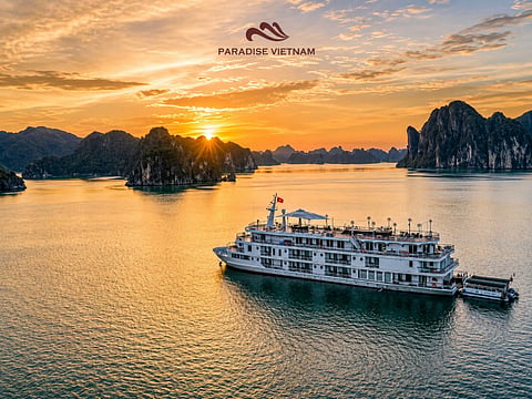 Cruise ship sailing in Ha Long Bay at sunrise.