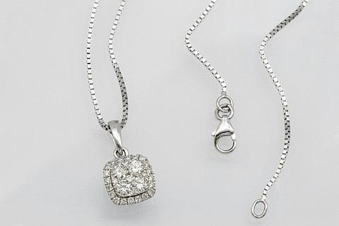 Diamond halo pendant necklace on a silver box chain.