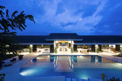 Resort swimming pool and clubhouse at twilight.
