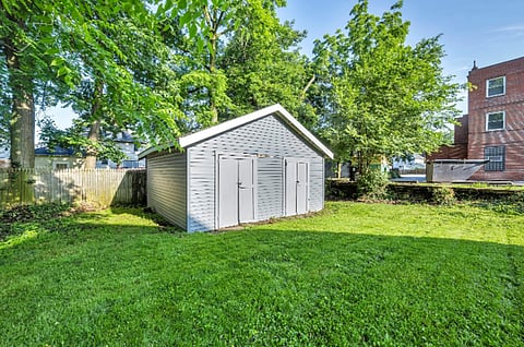 Gray backyard shed on a grassy lawn.