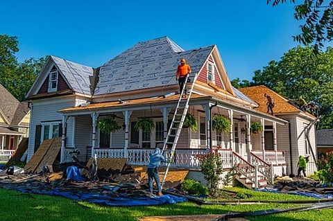 Workers replacing the roof on a house.