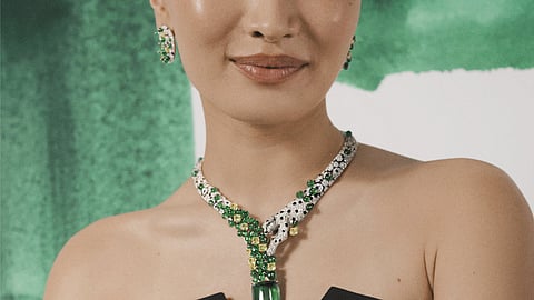 Anna Sawai in a black strapless dress wearing an emerald and diamond panther necklace