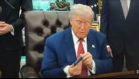 President Trump blir störd av sin telefon.