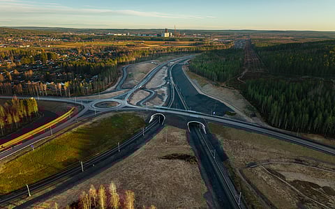 Det nya elektrifierade industrispåret, här sett från väster. Stegras blivande stålverk anas i bakgrunden vid den stora vita byggnaden med mörk skorsten. Spåret förbinder stålverket med järnvägen mellamn Kiruna och Luleå (nedanför bilden). Det nya industrispåret förgrenar sig i två spår för att tågen ska kunna åka ut på järnvägen åt båda håll.