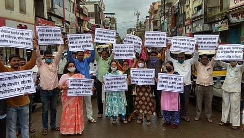 व्यापाऱ्यांचे हातात बोर्ड घेऊन प्रशासनाच्या विरोधात आंदोलन