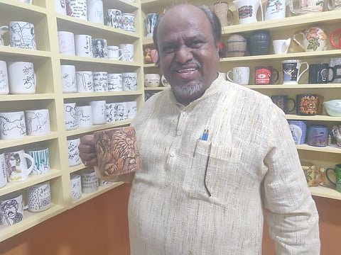 कलेक्शन केलेला मग दाखवताना अहमदनगरचे शिल्पकार प्रमोद कांबळे.