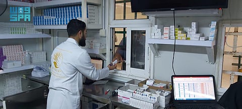 صيدلي يصرف وصفة طبية لمستفيد بمخيم الزعتري