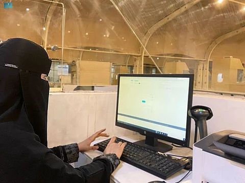 موظفة تعمل على إرشاد الحافلات الناقلة للحجاج