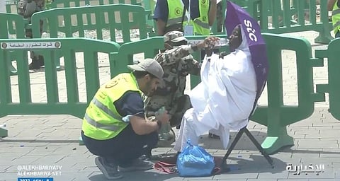 شاهد.. رجل أمن ومسعف يساعدان حاجّة أصيبت بالإعياء