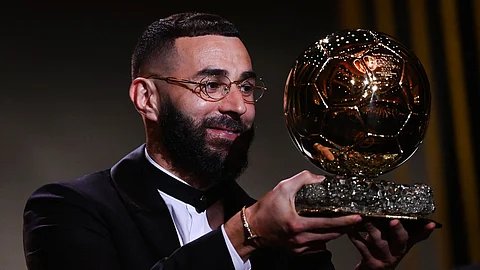 كريم بنزيما حاملا الكرة الذهبية