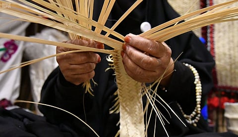 سفرة طعام ومظلة وقبعة.. "أم محمد" تروي عن صناعة الخوص التراثية بالباحة