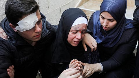 أم فلسطينية مكلومة من جنازة زوجها وطفليها
