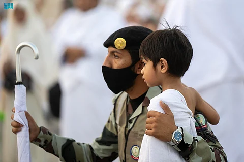 رجل أمن يعتني بأحد الصبية في مشهد لا يخلو من الأمان والاطمئنان