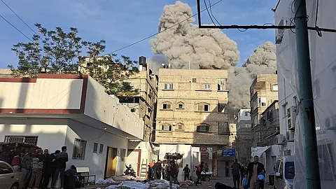 فلسطينيون يركضون للاختباء بجوار الجثث بعد غارة إسرائيلية بالقرب من مستشفى كمال عدوان