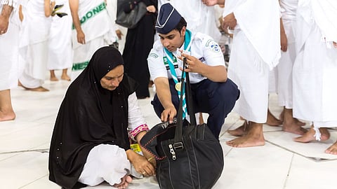 أحد منسوبي الكشافة السعودية يقدم الخدمات التطوعية للمعتمرين